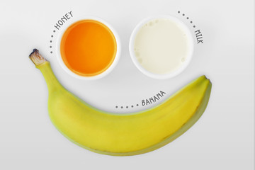 Obraz na płótnie Canvas Homemade face mask made out of honey, milk and banana on white background