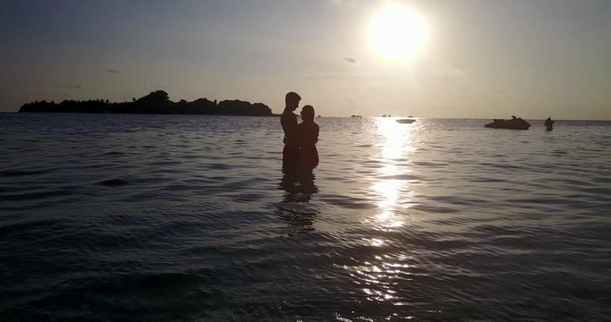 Silhouette of a young loving couple hugging and enjoying their vacations on a beach in Malaysia 4K footage