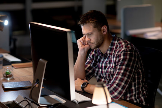 Young male professional working late in creative office