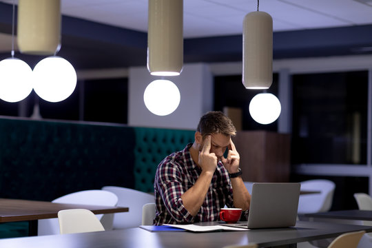 Young Male Professional Working Late In Creative Office