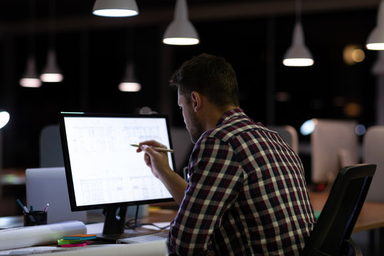 Young male professional working late in creative office