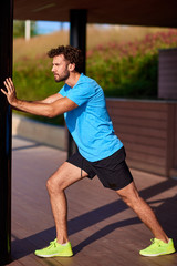 Fototapeta premium Man stretching and exercising in urban surroundings.