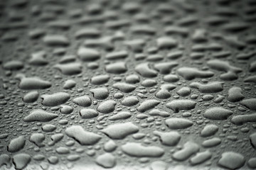 Gray steel drops of water. Gray textured background splash with blurry focus.