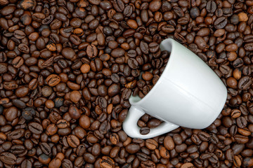 Pattern of roasted coffee beans with white coffee cup