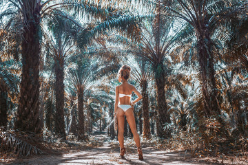 beautiful young woman in white bikini on tropical nature background