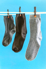 Three different socks on white rope and blue background