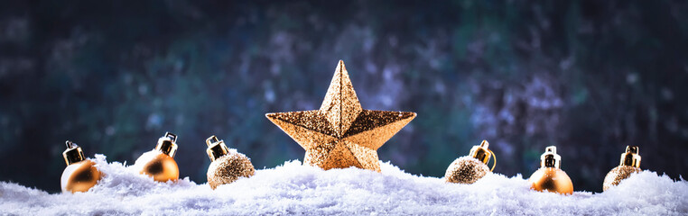 Christmas background with golden star. New Year's decor. Christmas balls in smowdrifts and golden...