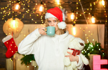 Fototapeta na wymiar Woman toy bear present. girl in santa hat drink tea. coffee time. Cheerful woman in sweater. happy to be here. winter holidays celebration. happy new year. christmas preparation. xmas mood