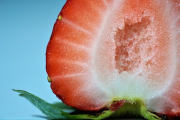 macro view on slice of bright fresh strawberry on a white background