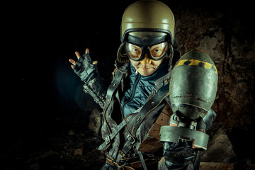 Fototapeta premium Soldier woman with the bomb on post apocalyptic background.