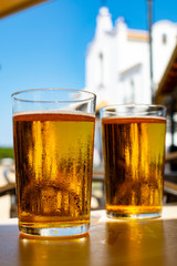 Cold amber color light spanish beer served in glass in outdoor cafe in town on sand, El Rocio in Andalusia, Spain