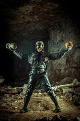 Fototapeta premium Soldier woman with the bomb in one hand and skull in another on the ruined background.