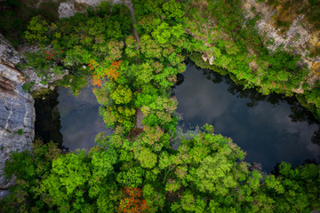 Aerial view of round shaped pond in autumn forest