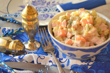 Traditional Russian cuisine: Olivier salad. White and blue colors of design of festive table, gzhel style