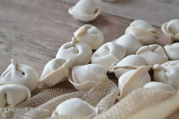 Fototapeta na wymiar preparation of russian meat dumplings. Homemade raw dumplings on a wooden white table close up