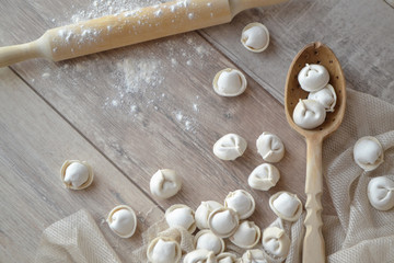 raw dumplings with flour on the rustic white table with rolling pin,