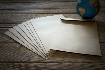 Brown Letter Envelop with globe on wooden table