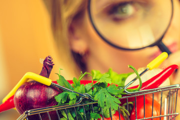 Woman investigating shopping backet with vegetables
