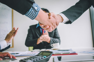 Business people shake hands after agreeing to join a business