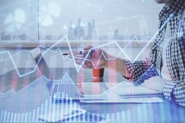 Double exposure of stock market chart with man working on computer on background. Concept of financial analysis.