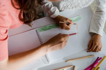cropped view of babysitter drawing with kid in living room