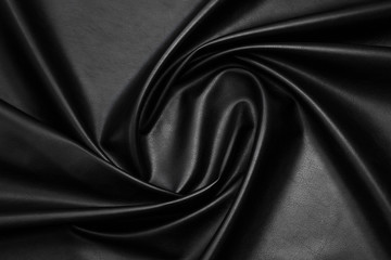 black artificial leather with waves and folds on PVC base