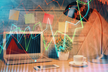 Double exposure of graph and financial info and work space with computer background. Concept of...