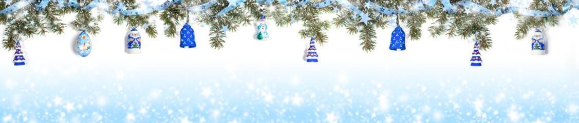 Extra wide Christmas border with fir branches, snow, shiny ribbon, christmas toys on gradient blue background with snow. - obrazy, fototapety, plakaty