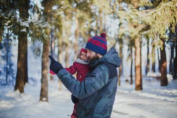 Fototapeta na wymiar winter walk with a child: dad and daughter walk in the winter forest 1