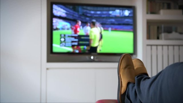 A person watches a soccer game on TV