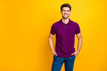 Photo of confident cheerful reliable business person holding his hands in pockets smiling toothily beaming looking successful isolated over yellow vivid color background