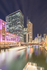 Boat tour light trail and Chicago skylines at blue hour with marina cove patio