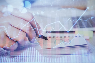 Multi exposure closeup hands with stock market forex graph.