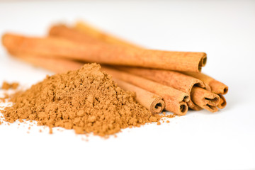 Cinnamon sticks and cinnamon powder herbs and spices on white