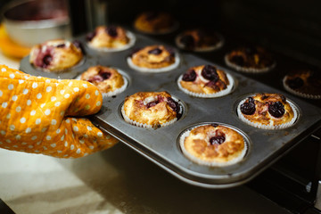 Homemade muffins with cherries in a baking form.