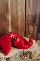 red pepper on a stump on a wooden background