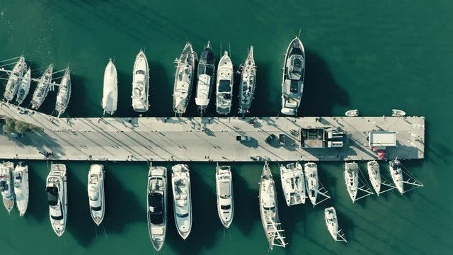 Aerial top down view of docked sailing yachts at marina pier, Greece
