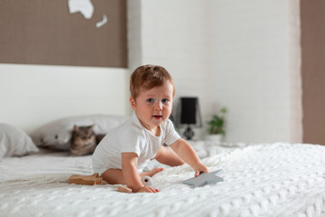Happy baby sitting on a big bed