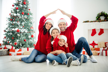Portrait of four nice attractive lovely sweet idyllic affectionate cheerful big full careful family brother sister celebrating newyear leisure showing roof in light white interior living-room