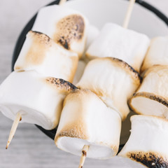 Roasted marshmallowsÂ on sticks on cup