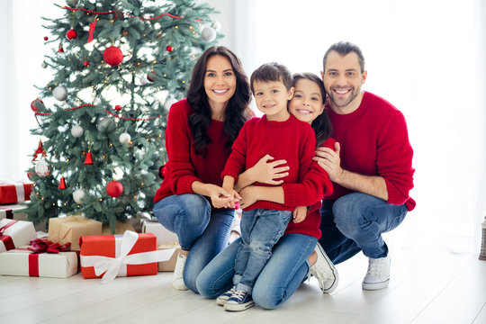 Full size photo of big full family positive mommy daddy kids sitting near evergreen fir tree with gift box presents for christmas time x-mas in house indoors