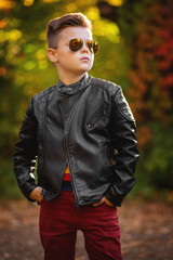 authentic boy in black leather bikers' jacket and sunglasses looking away.