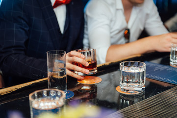 Group of friends having drinks whiskey at the night club after work .