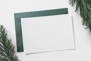Sheet of paper with green envelope on table