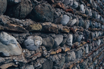 Rough paved wall with sea stones.