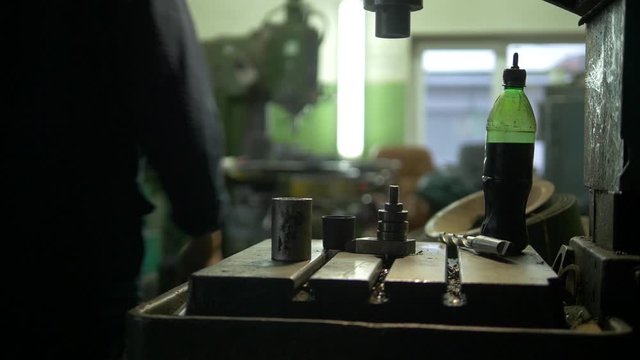 There is a lot of heavy machinery and other gear on a plant. A factory worker is heading to his workplace. We can see some tools he uses.