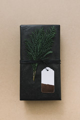 Black gift box with green cypress branch