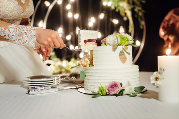 Happy bride and groom cut the cake. Evening ceremony