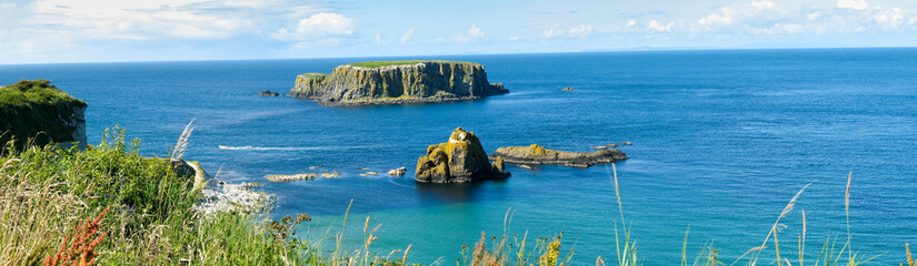 Panoramic view of Rocky islands on the turquoise ocean, cliffs of Northern Ireland