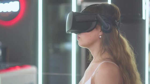 Girl in virtual reality glasses holds an imaginary line in the form of a hyperbola